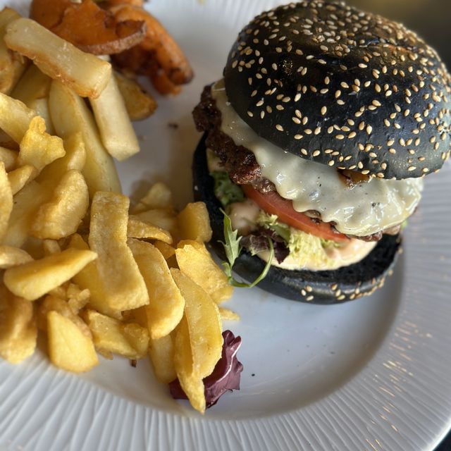 hamburguesa con pan negro y patatas fritas